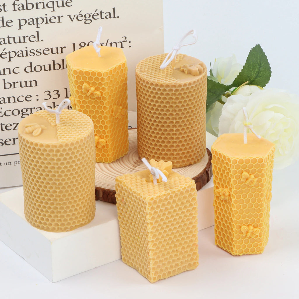 Five yellow and tan honeycomb pillar example candles with round, hexagonal and square profiles
