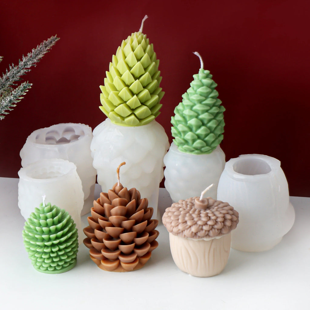 Set of pine cone and acorn-shaped candles on a white surface with a red background
