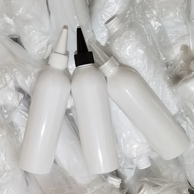 White pointed-nozzle bottles resting on protective packaging