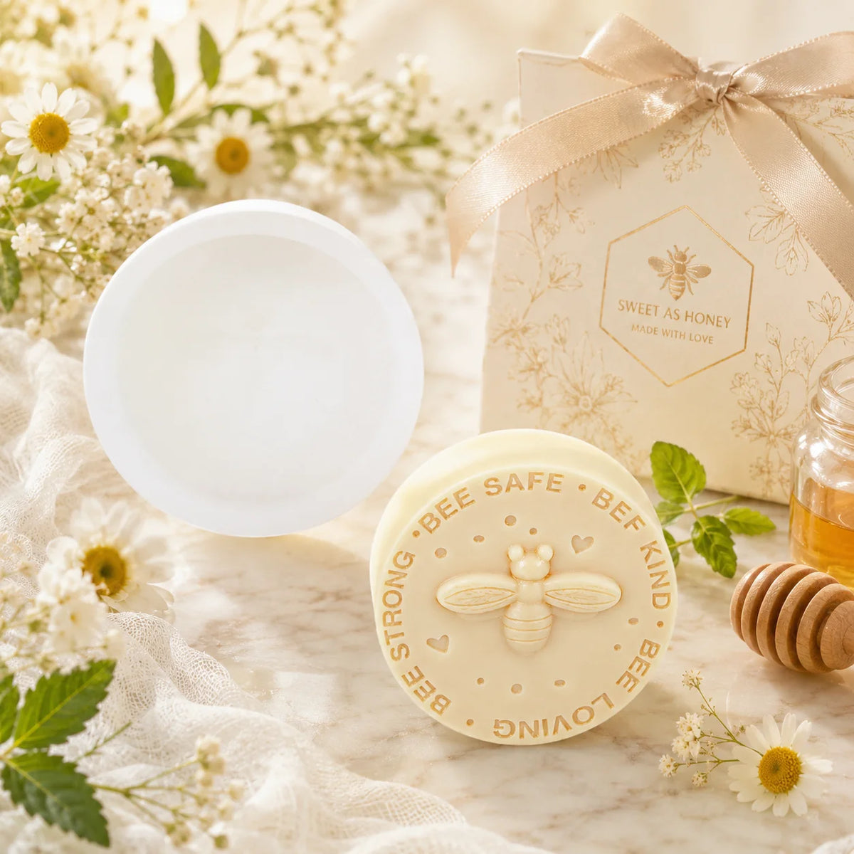 Round bee slogan casting beside its white mold, flowers and a honey dipper