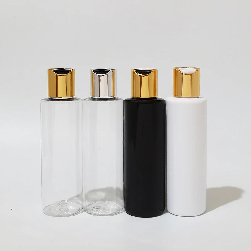 Clear, black and white bottles with gold-tone and silver-tone disc-top caps