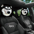 Two car headrests featuring printed husky dog faces, installed on the front seats of a black car interior. A white '2pcs' text overlay is visible on the left headrest.