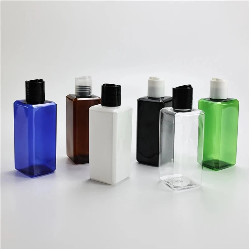 Assorted blue, brown, white, black, clear and green square bottles with disc-top caps