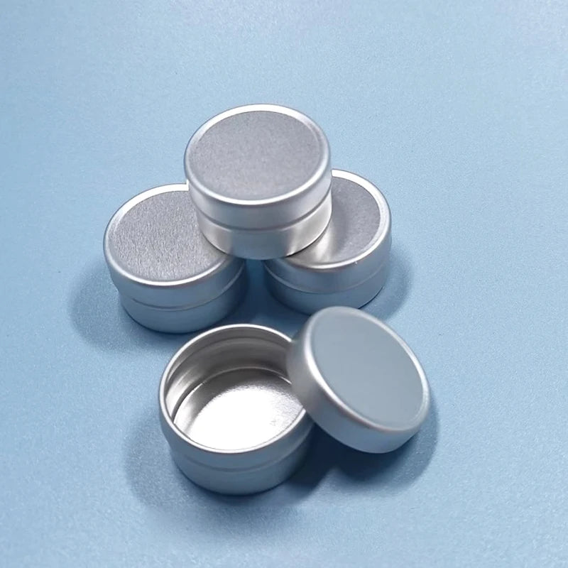 Small round silver aluminum tins with screw lids, one tin shown open