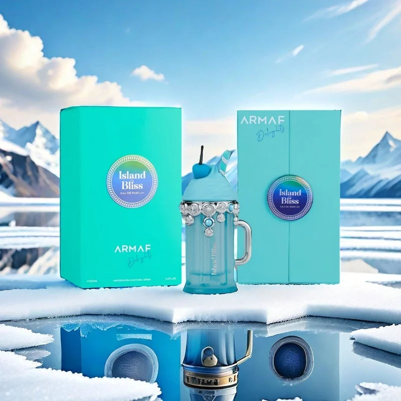 ARMAF Island Bliss insulated tumbler set with turquoise packaging boxes, shown on a snowy icy surface with mountain scenery in the background. The set includes a turquoise tumbler with a handle and straw, a matching box, and another turquoise box.