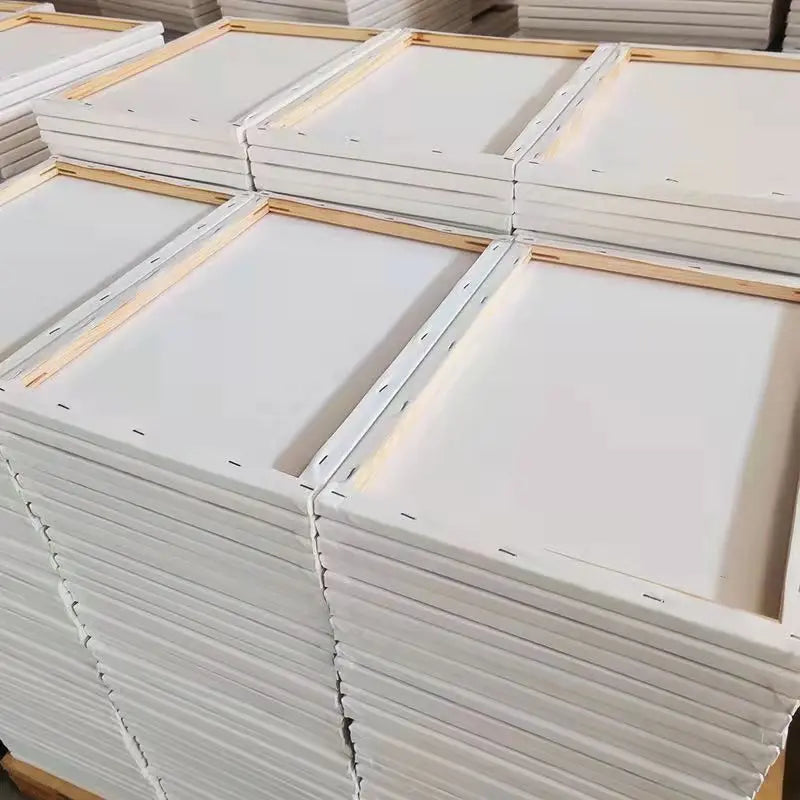 Stacks of white canvases with wooden frames on a light background