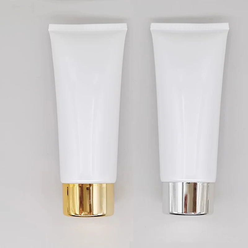 White squeeze tubes with gold-tone and silver-tone cylindrical caps