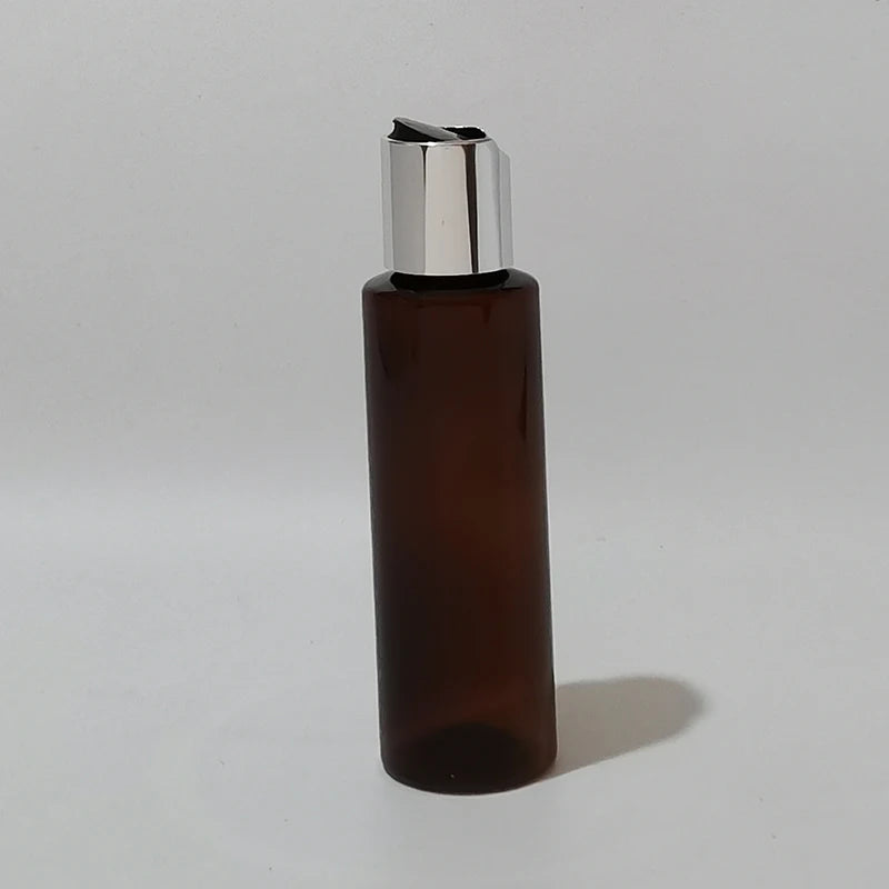 Brown empty bottle with a silver-tone disc cap and black insert