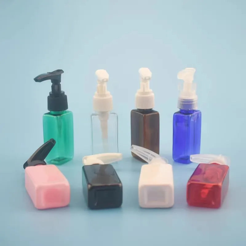 Small rectangular bottles in assorted colors with pump and flip-top closures in a group display