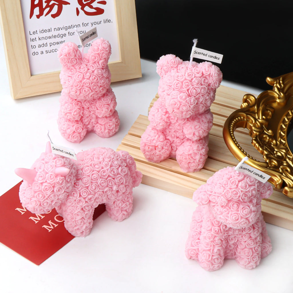 Pink rose-textured rabbit, bear, unicorn and dog candles with paper scent tags