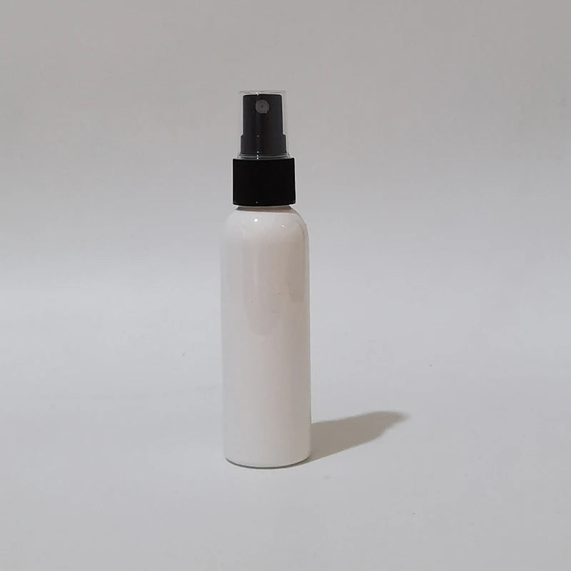 White round spray bottle with black sprayer and clear protective cap