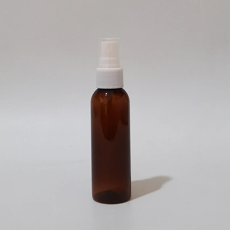 Brown round spray bottle with white sprayer and clear protective cap