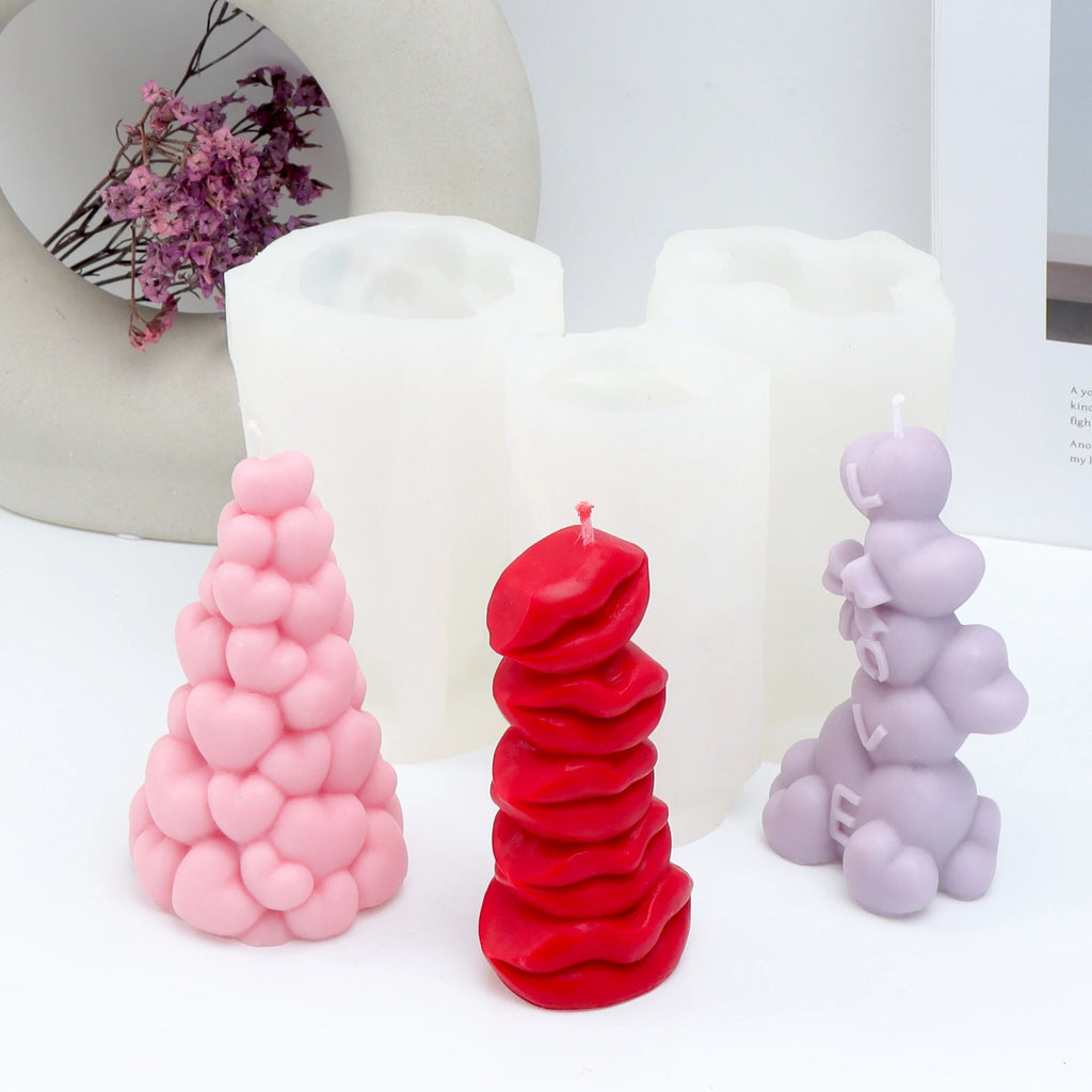 Three pillar candle examples with heart and stacked-lips designs in front of white silicone molds