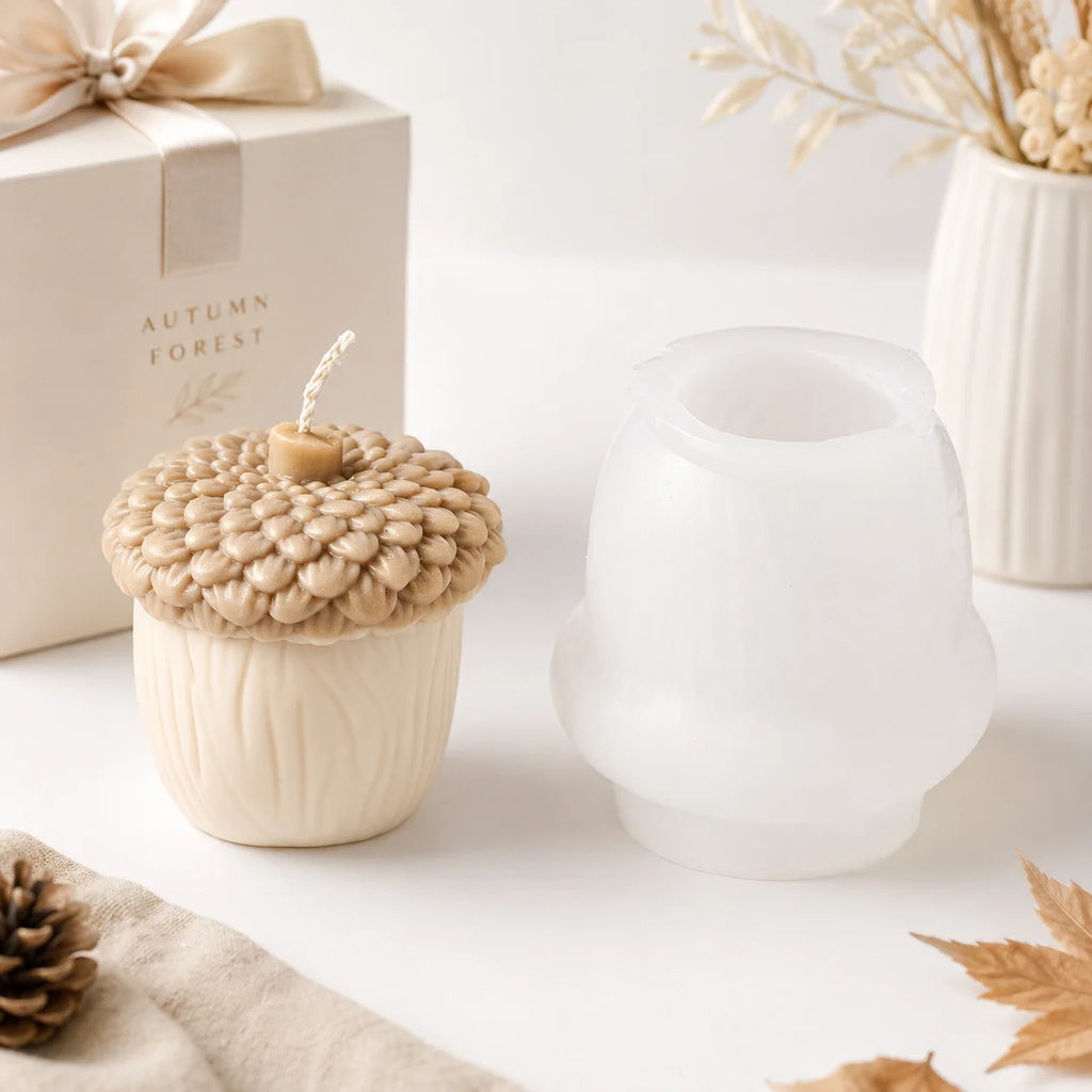 Ivory acorn example candle with textured cap beside a white silicone mold