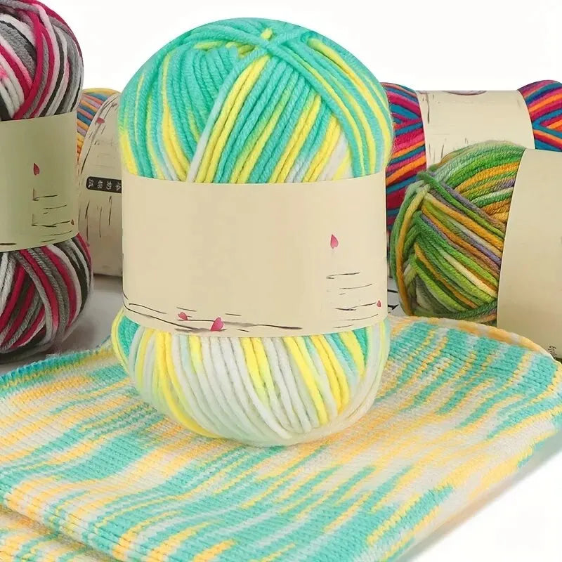Turquoise, yellow and white variegated yarn skein on a matching striped knitted swatch.