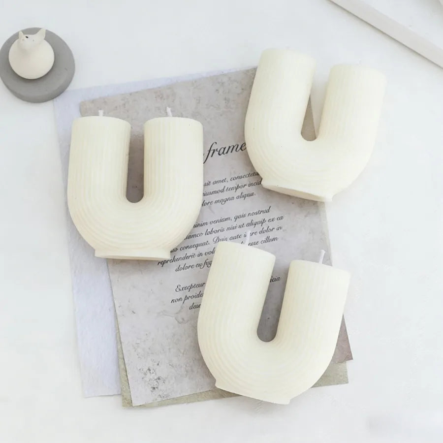 Letter-shaped candles on a textured surface