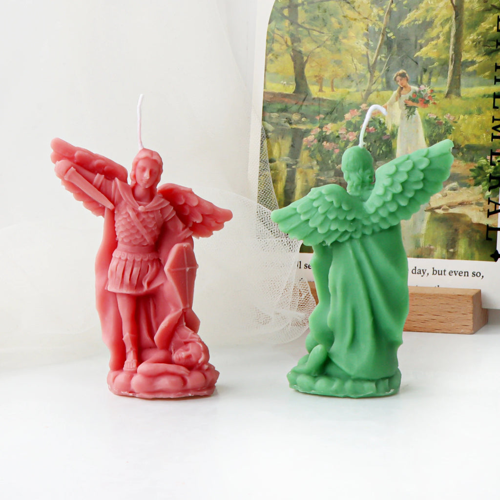 Front of a pink archangel example candle and rear view of a green casting showing feathered wings