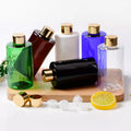 Green, brown, white, blue, clear and black PET bottles with gold-tone screw caps