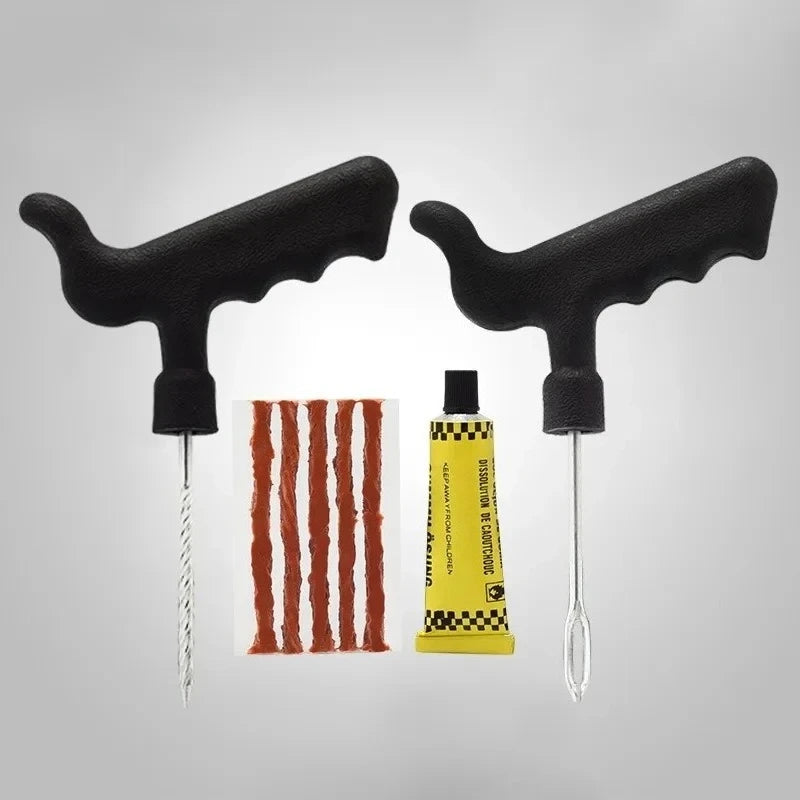 Two black handles with a tube of yellow glue with tire plugs and a red and white striped object on a gray background