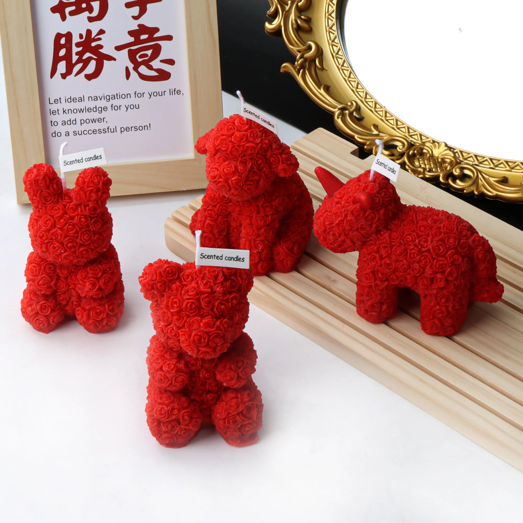 Red rose-textured rabbit, bear, dog and unicorn candles arranged around a wooden display stand