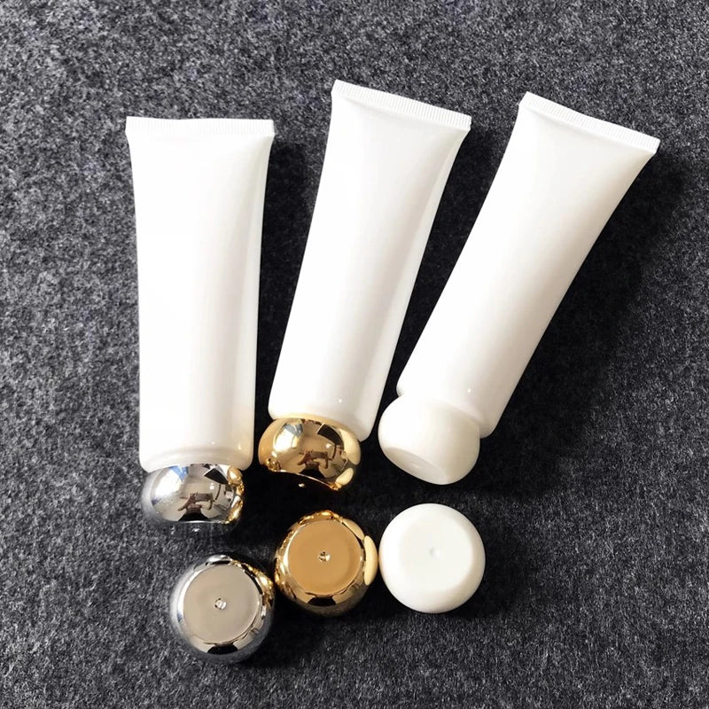 White squeeze tubes with gold-tone, silver-tone and white rounded screw caps