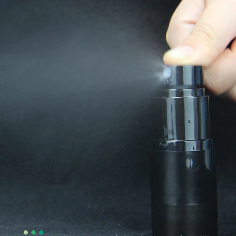 Hand pressing a black spray bottle nozzle to release a mist