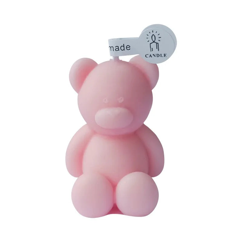 Pink seated teddy bear candle with a small handmade candle tag above its head