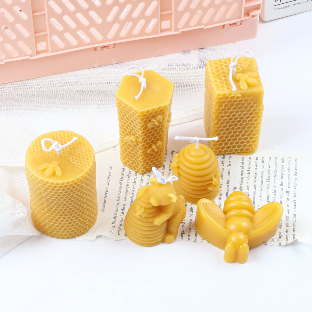 Yellow bee-theme example candles including honeycomb pillars, beehives, bear with hive and a large bee