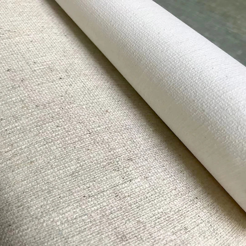 A close-up of a rolled off-white canvas woven surface, shown against a neutral gray background.