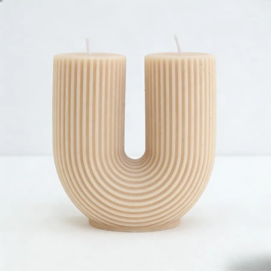 Candle shaped like the letter 'U' on a white background