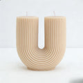 Candle shaped like the letter 'U' on a white background