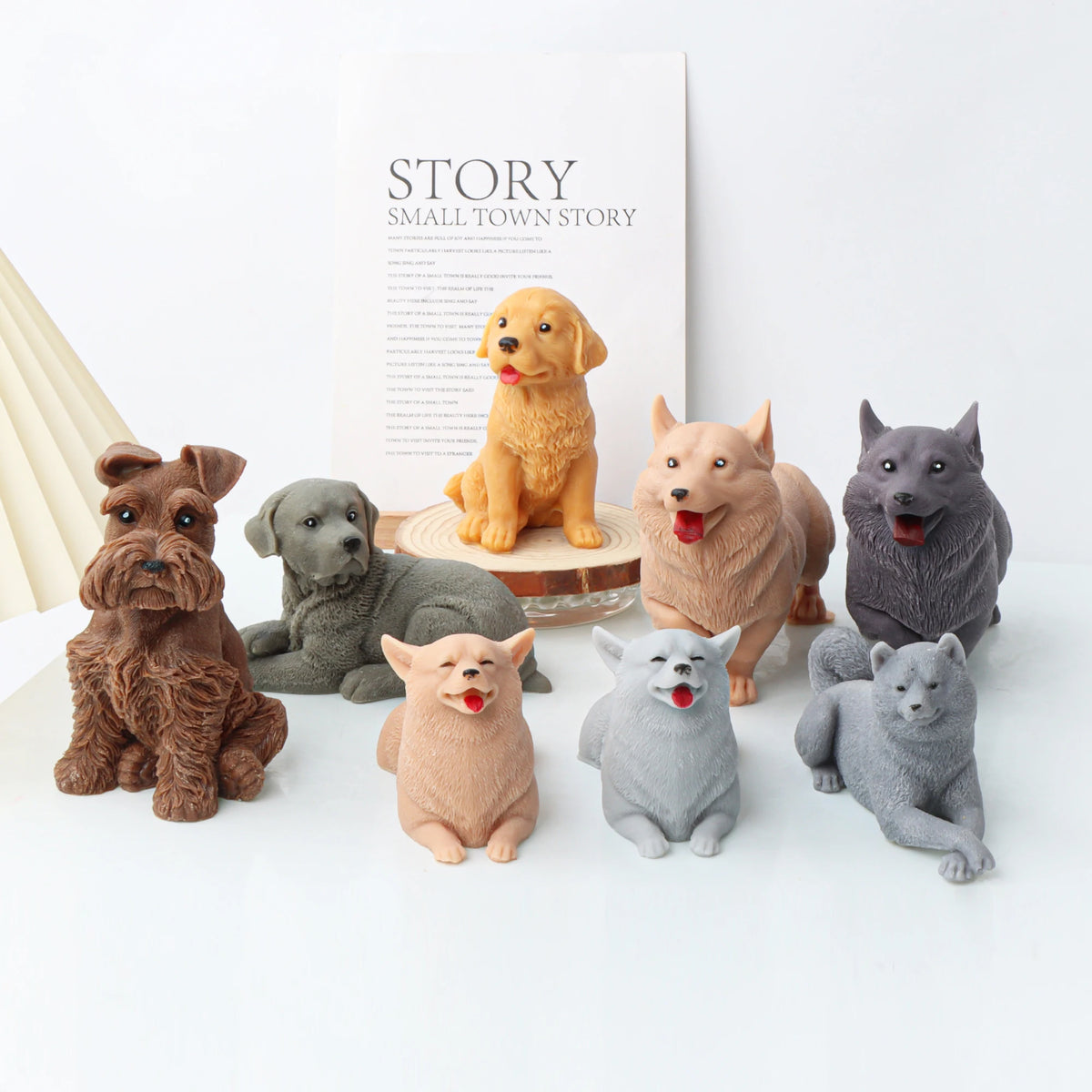 Collection of dog candle mold figurines in various breeds on a white surface with 'Story' branding in the background.