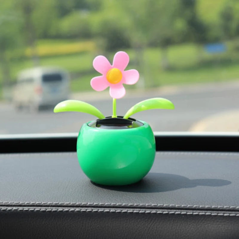 Decorative flower on a car dashboard with a blurred outdoor background
