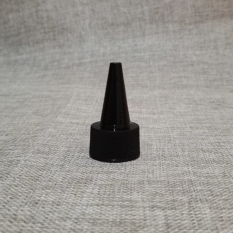 Single black pointed-nozzle bottle closure on textured fabric
