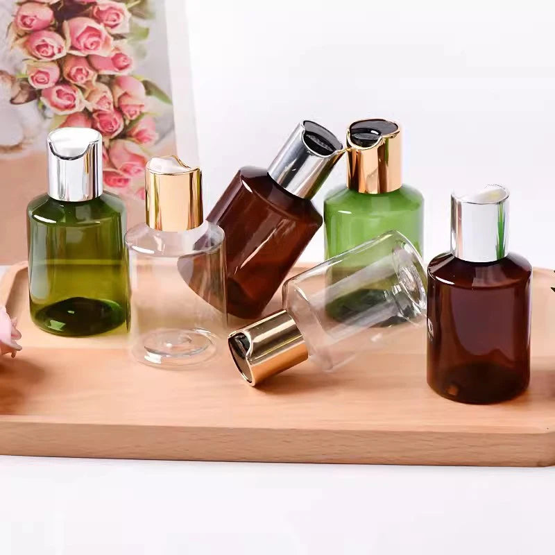 Assorted empty cosmetic bottles with gold-tone and silver-tone disc-top closures beside roses