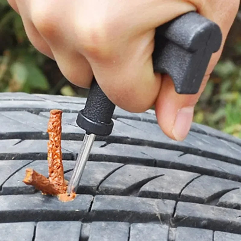 Person using a tire repair tool on a tire for a tire plug