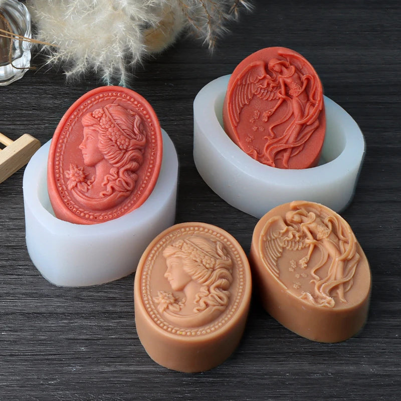 Tan and red cameo and winged figure soap casting examples displayed with white oval silicone molds