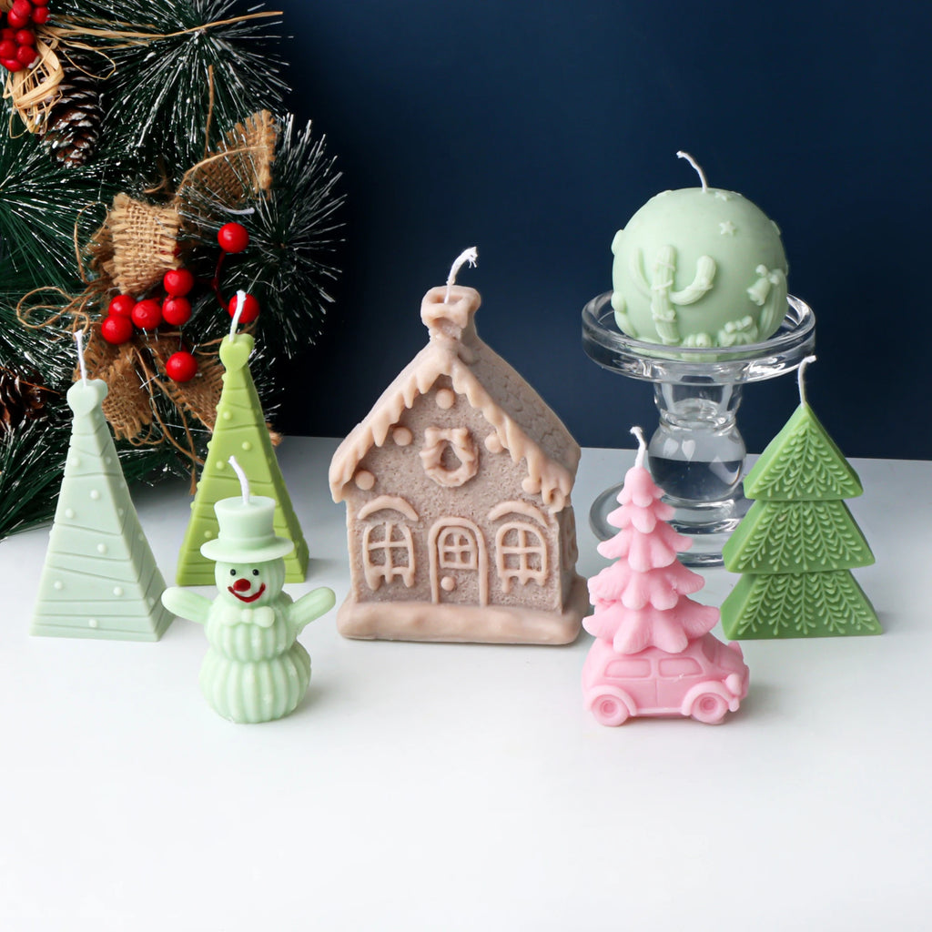 Christmas casting examples arranged before a holiday tree, including a cottage and tree-topped car