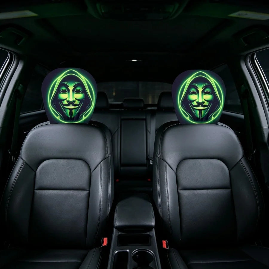 Two circular car headrest covers installed on the front seats of a black car interior, featuring a glowing green and yellow Guy Fawkes mask design.