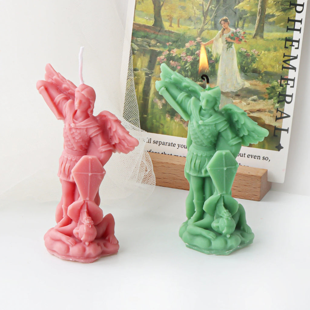 Pink and green St Michael archangel example candles, with the green candle lit