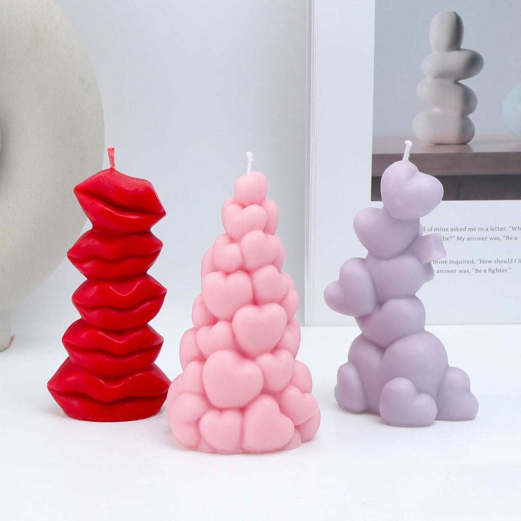 Red stacked-lips, pink clustered-heart and lavender heart-tower example candles