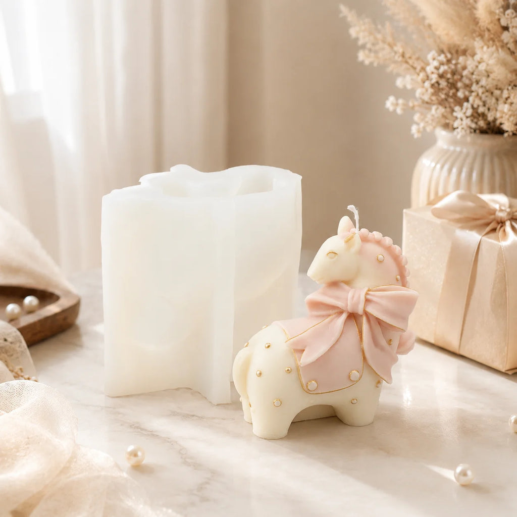 Ivory horse example candle with a pink bow and dotted saddle beside its white silicone mold