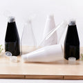 White, clear and black tapered bottles with clear flip-top caps