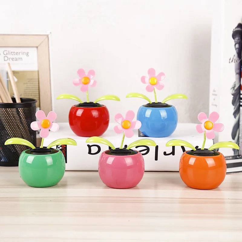 Colorful flower-shaped pots with moving flowers on a desk