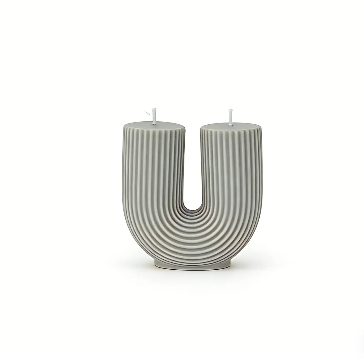 Cylindrical candle with a U-shaped design on a white background
