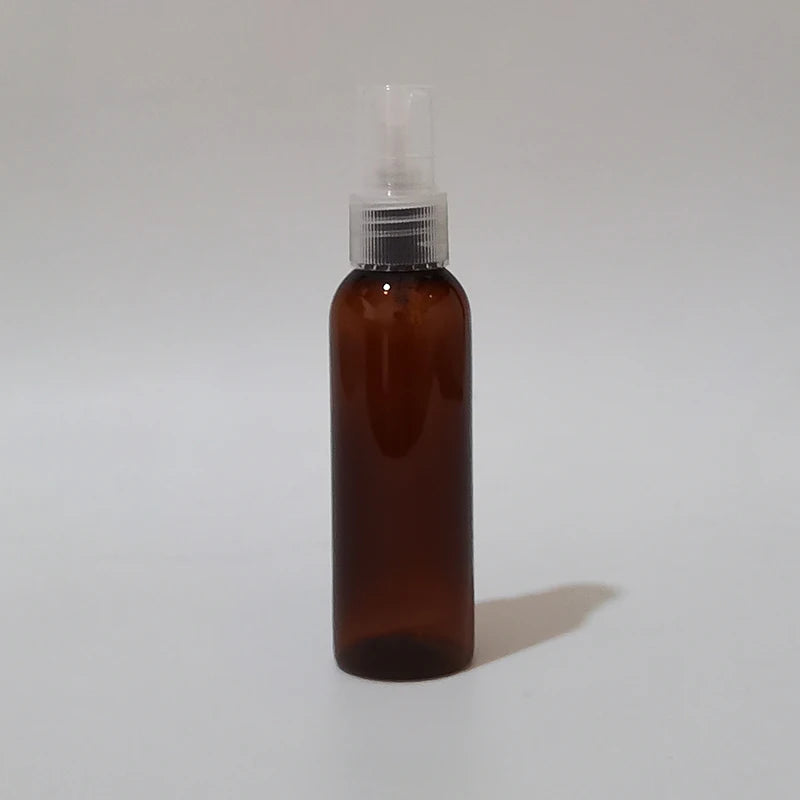 Brown round spray bottle with clear sprayer and protective cap