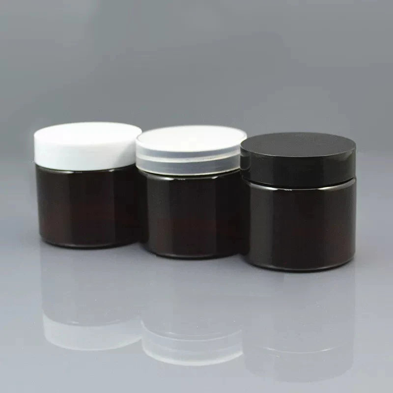 Three brown cosmetic jars with white, transparent and black lids