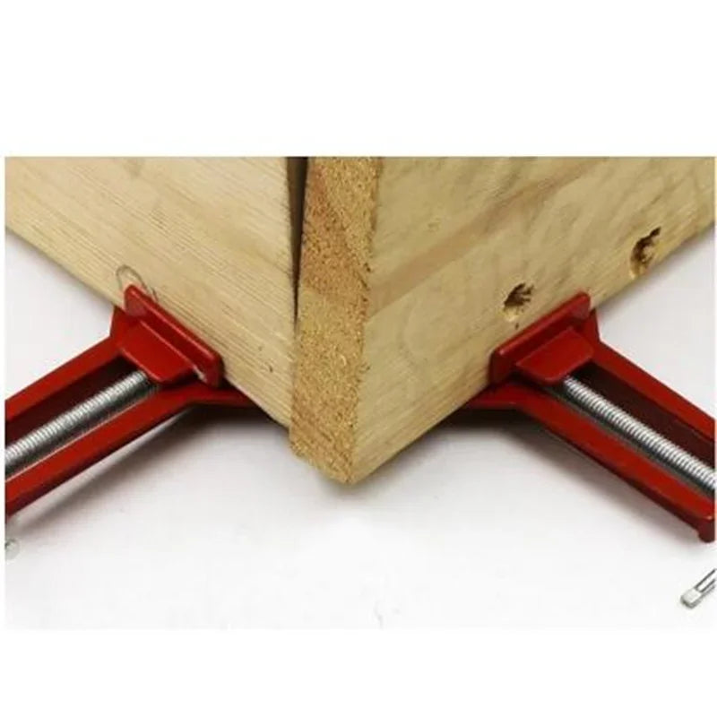 picture frame corner clamp holding two pieces of wood together on a white background